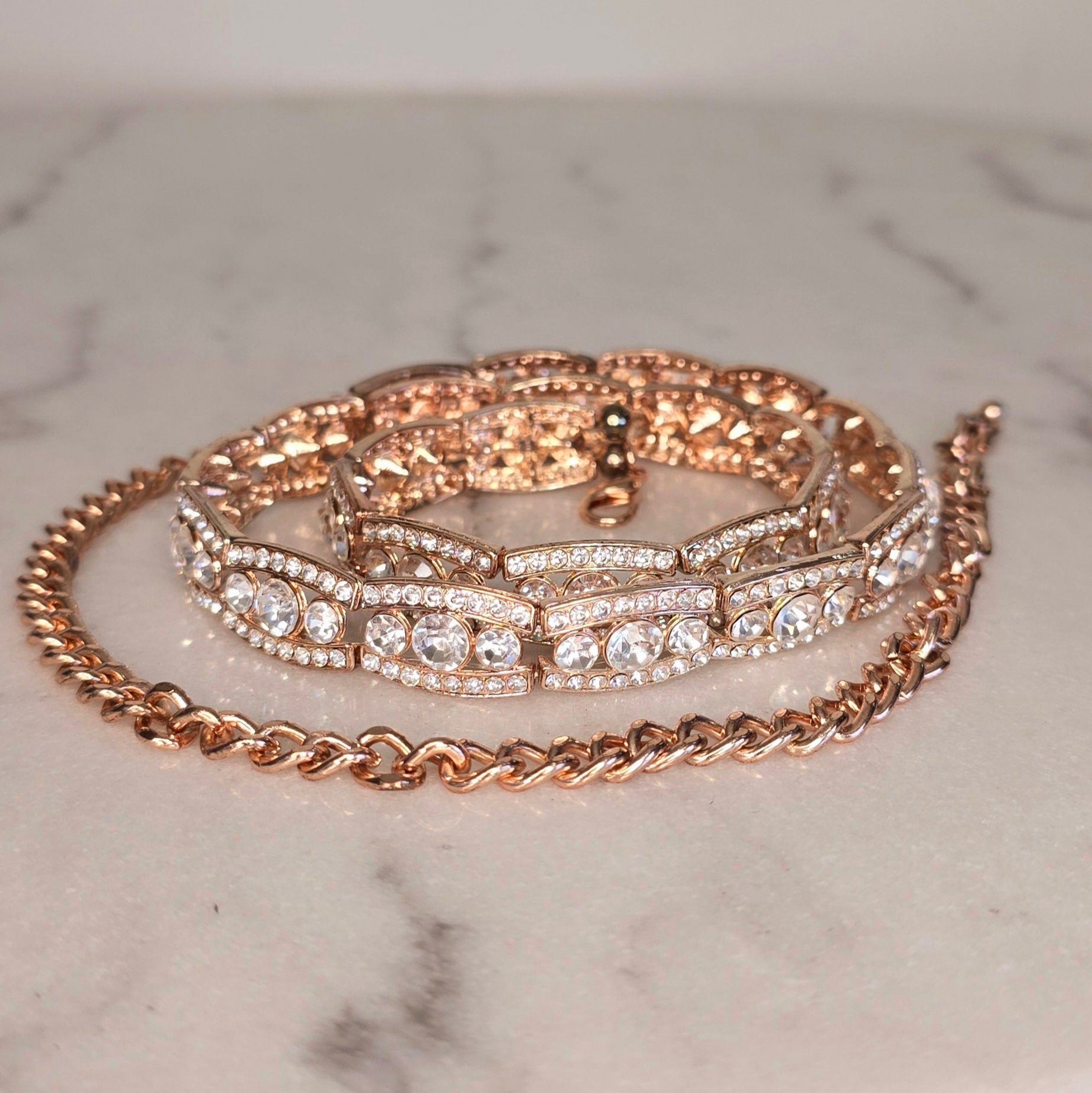 Rose gold belt with chain design on a marble surface