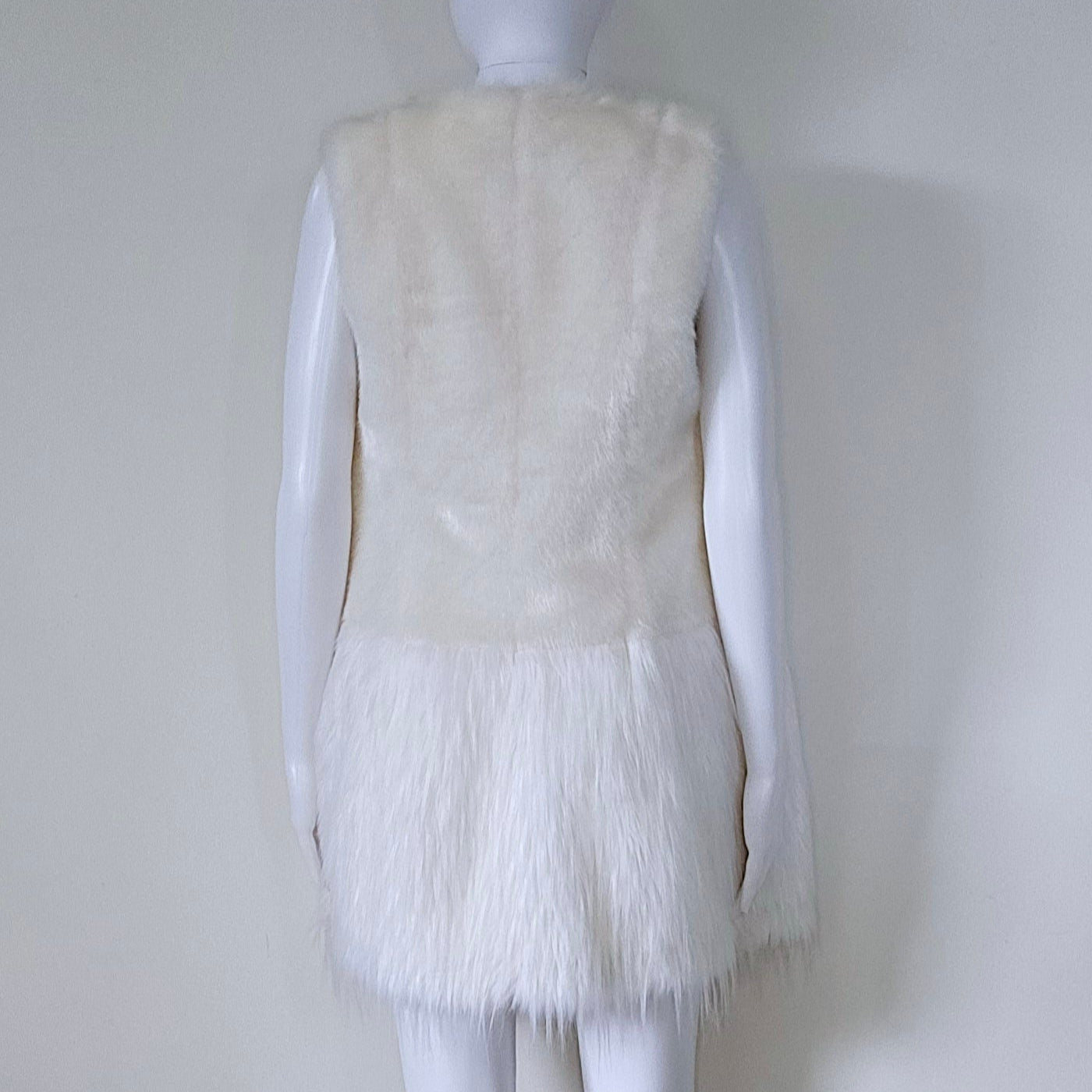 Mannequin wearing a white fur vest against a plain background