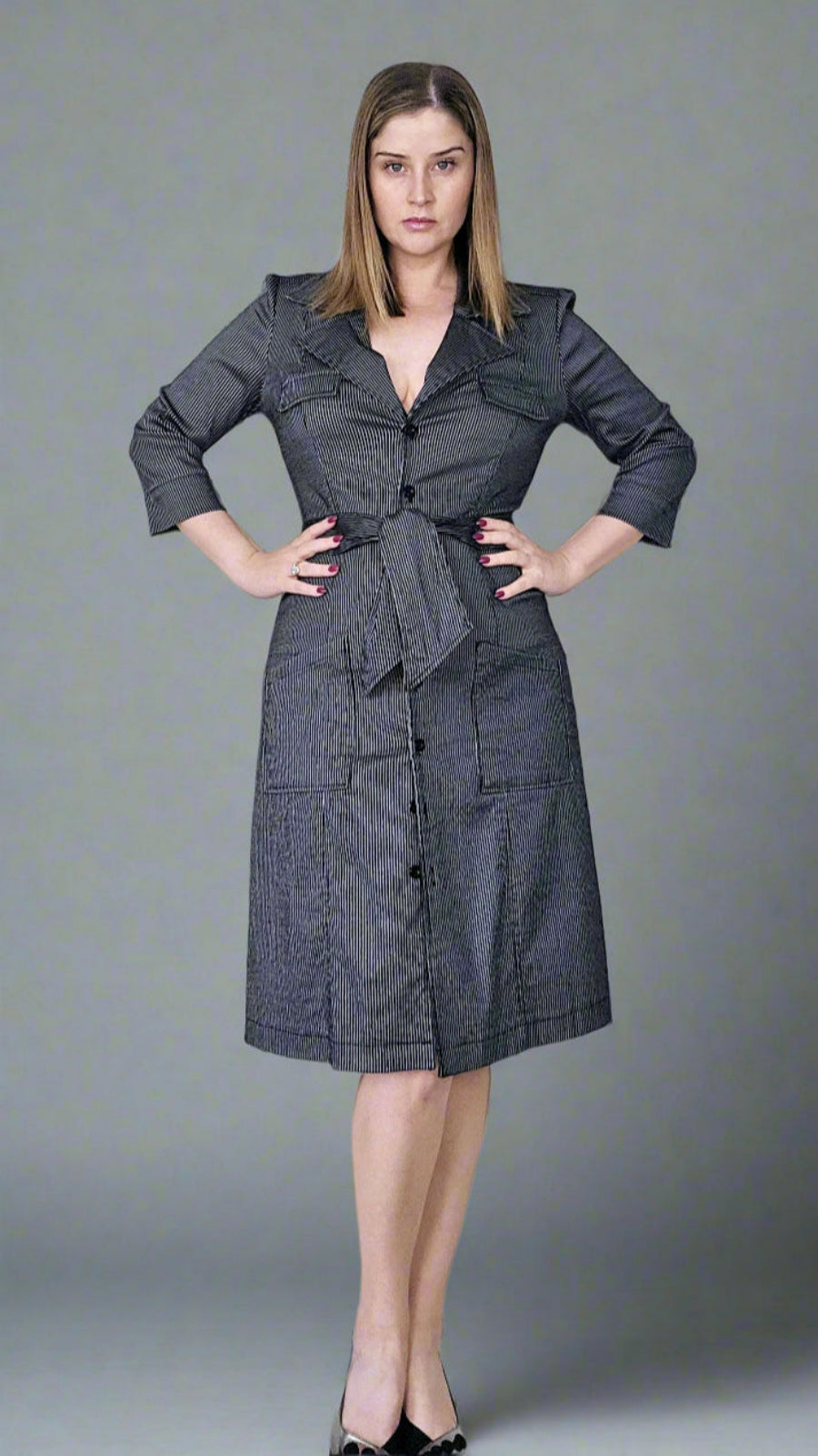 Woman wearing a gray dress against a gray background