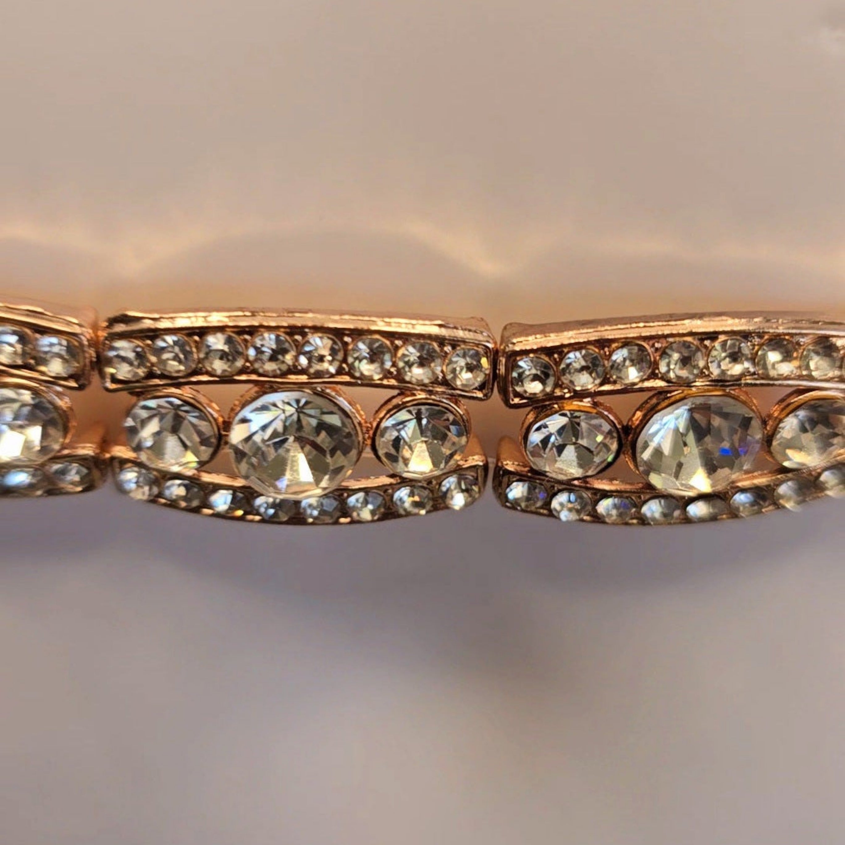 Rose gold belt with clear gemstones on a light gray background