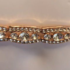 Rose gold belt with clear gemstones on a light gray background