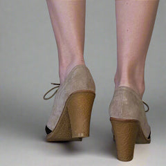 Beige wedge shoes on a neutral background