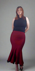 Woman wearing a black top and red skirt against a gray background