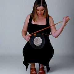 Woman holding a woven bag against a plain background