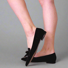 Black shoes worn by a person on a gray background