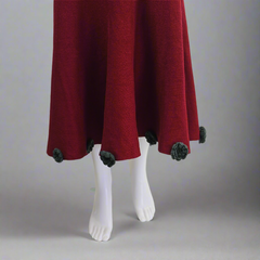Red skirt with green trim on a white mannequin against a gray background