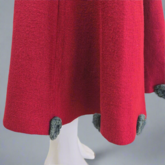 Red textured fabric with gray trim on a mannequin against a gray background