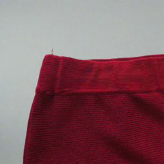 Close-up of a red textured fabric edge on a light gray background