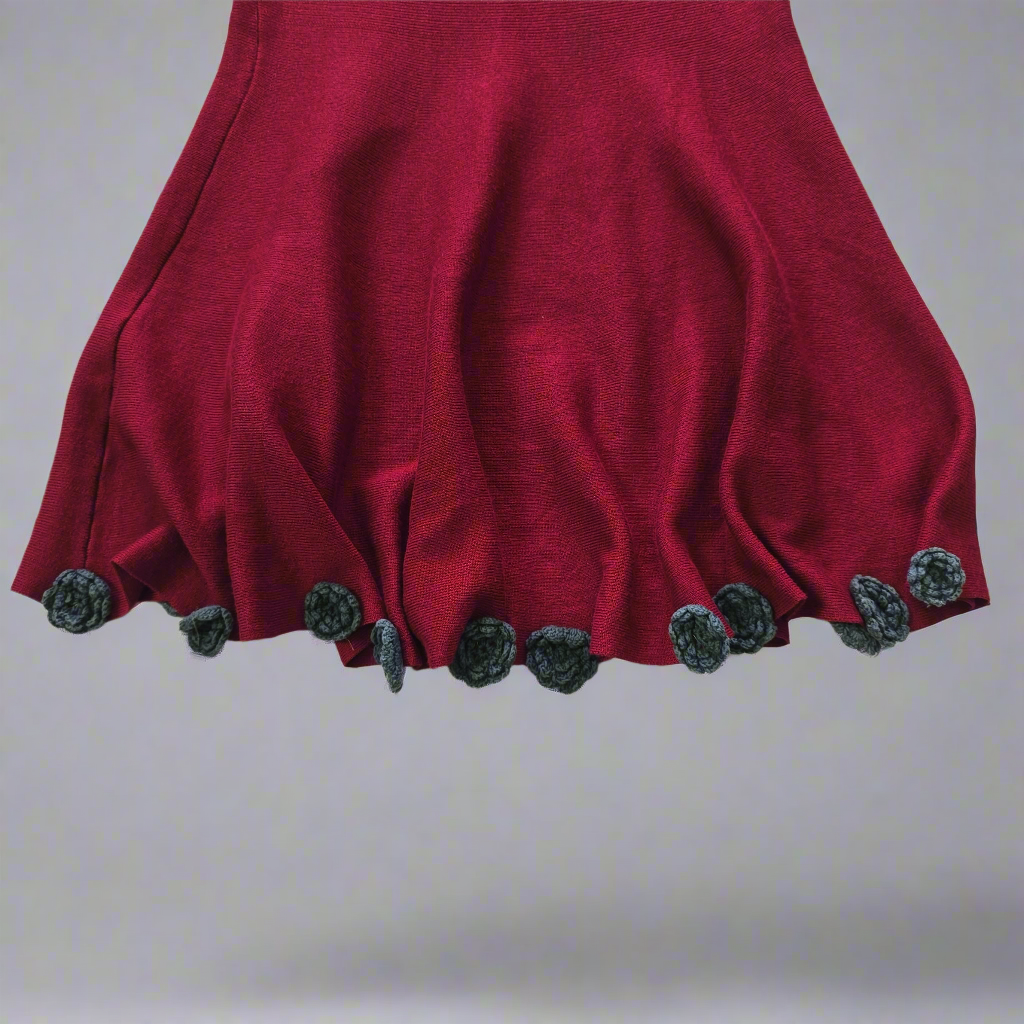 Red garment with floral embellishments on a plain background
