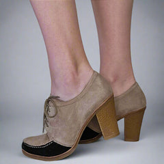 Beige suede shoes with wooden block heels on a neutral background