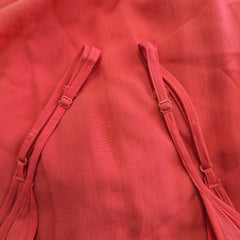 Close-up of a red fabric with straps on a matching red background