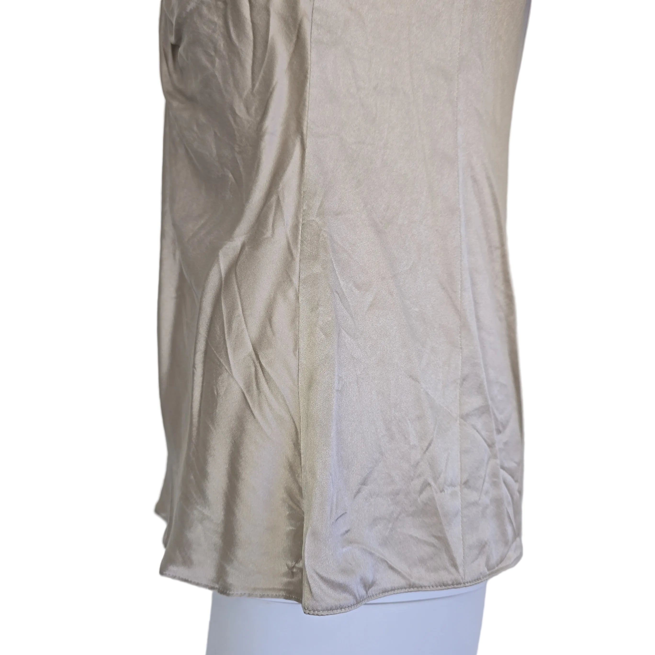 Beige top with a knot detail on alight floor