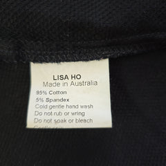 Label on a black garment with 'Lisa Ho' branding and fabric information.