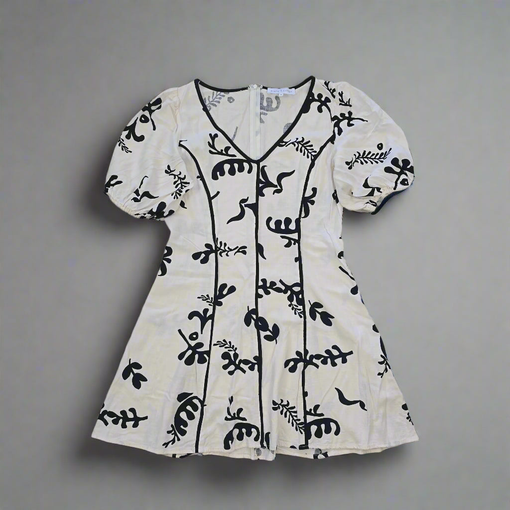 White garment with black floral patterns on a tiled floor