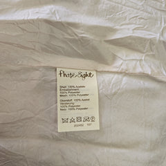 Close-up of a label on a beige fabric with 'Fluide Eight' branding.