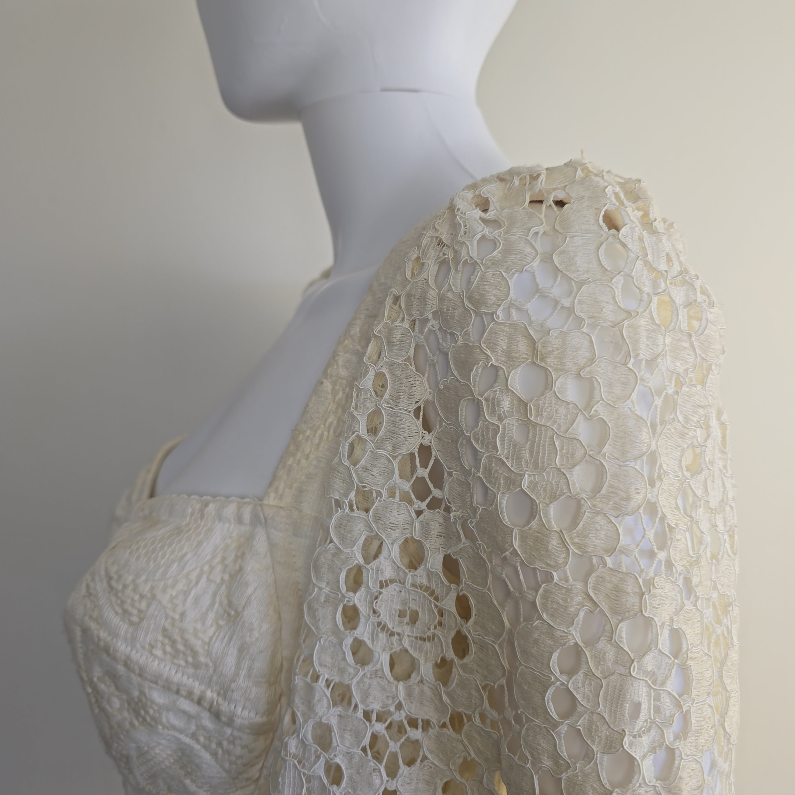 Mannequin wearing a beige lace dress with a neutral background