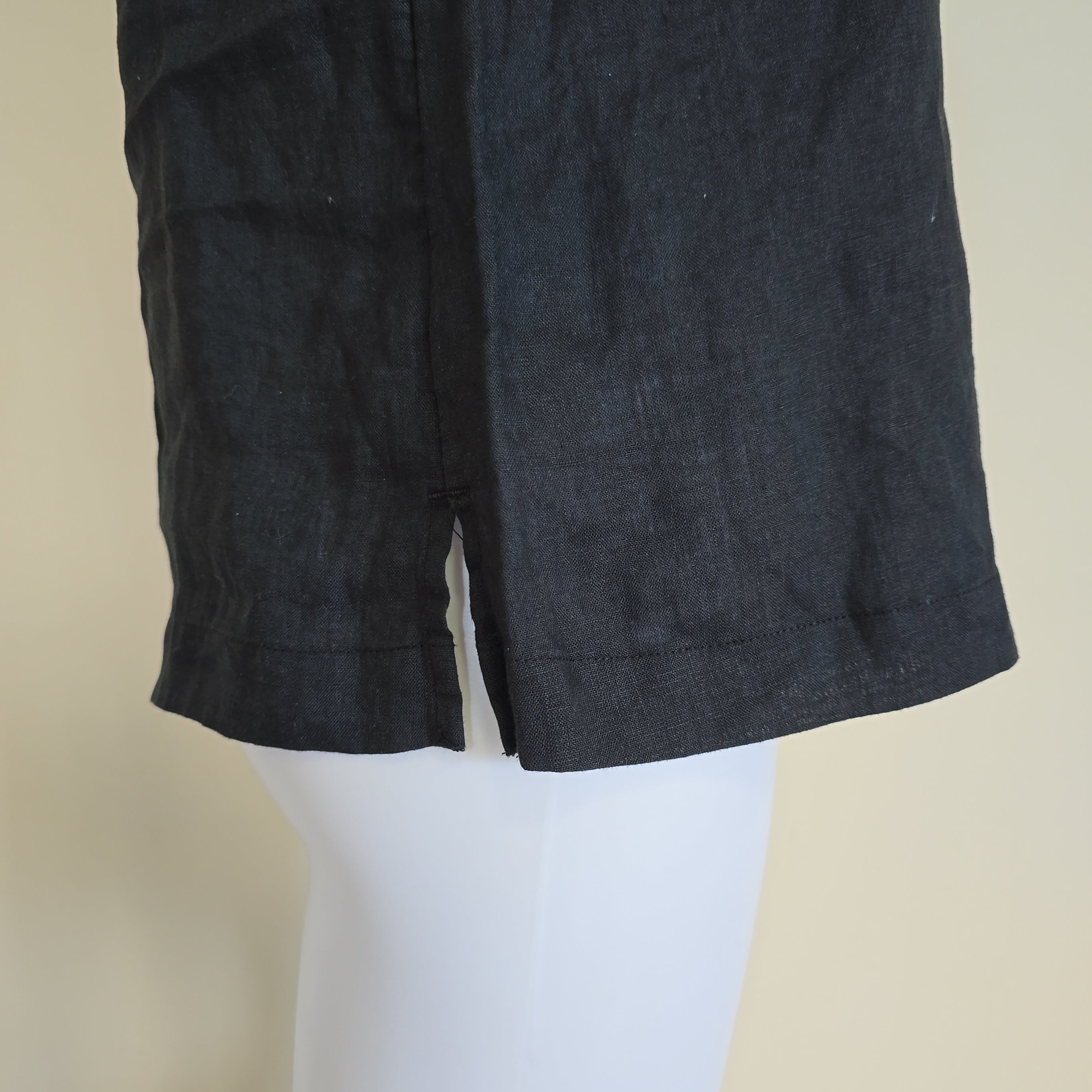 Dark black fabric on a mannequin against a beige background