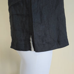 Dark black fabric on a mannequin against a beige background