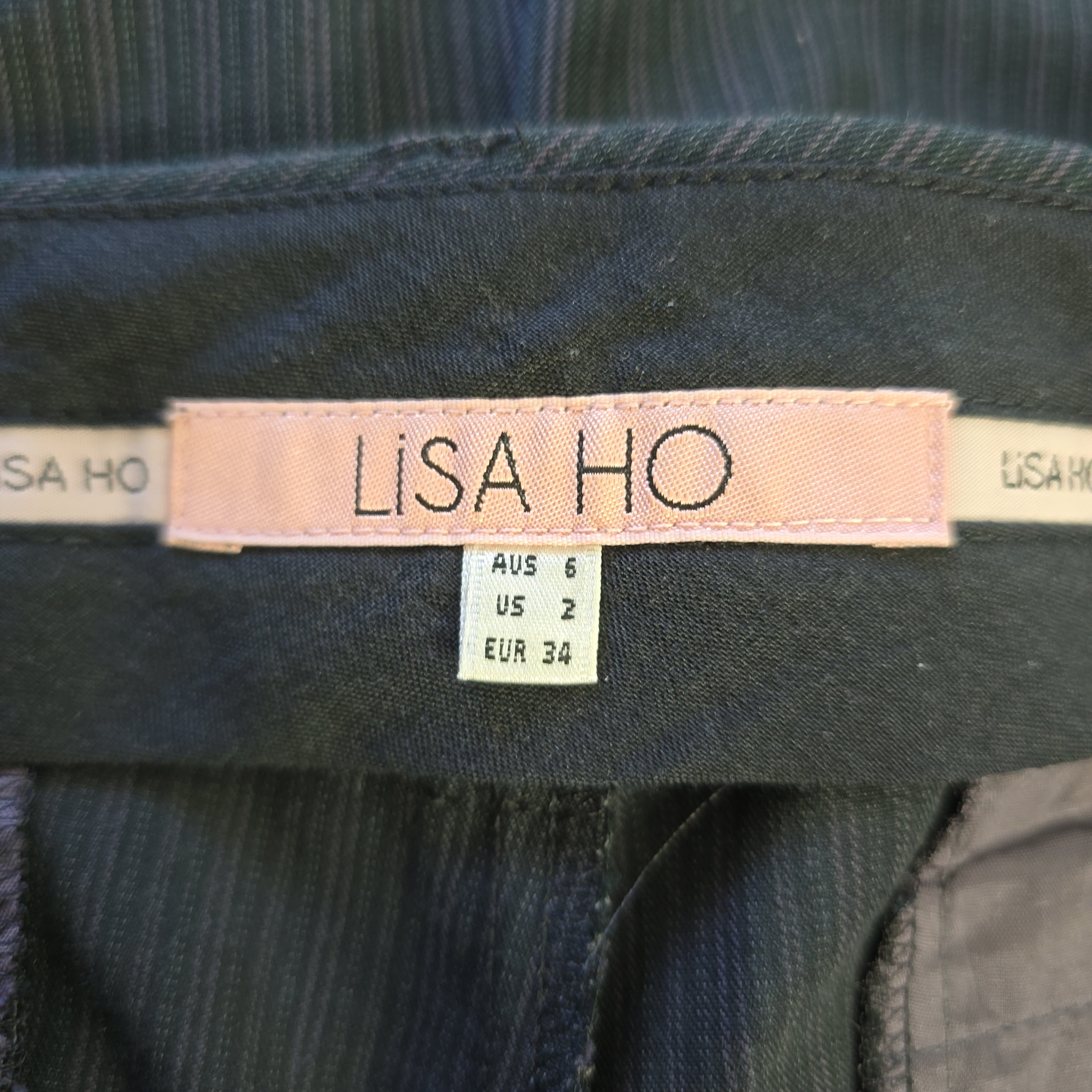 Close-up of a clothing label on a garment with 'LISA HO' branding.