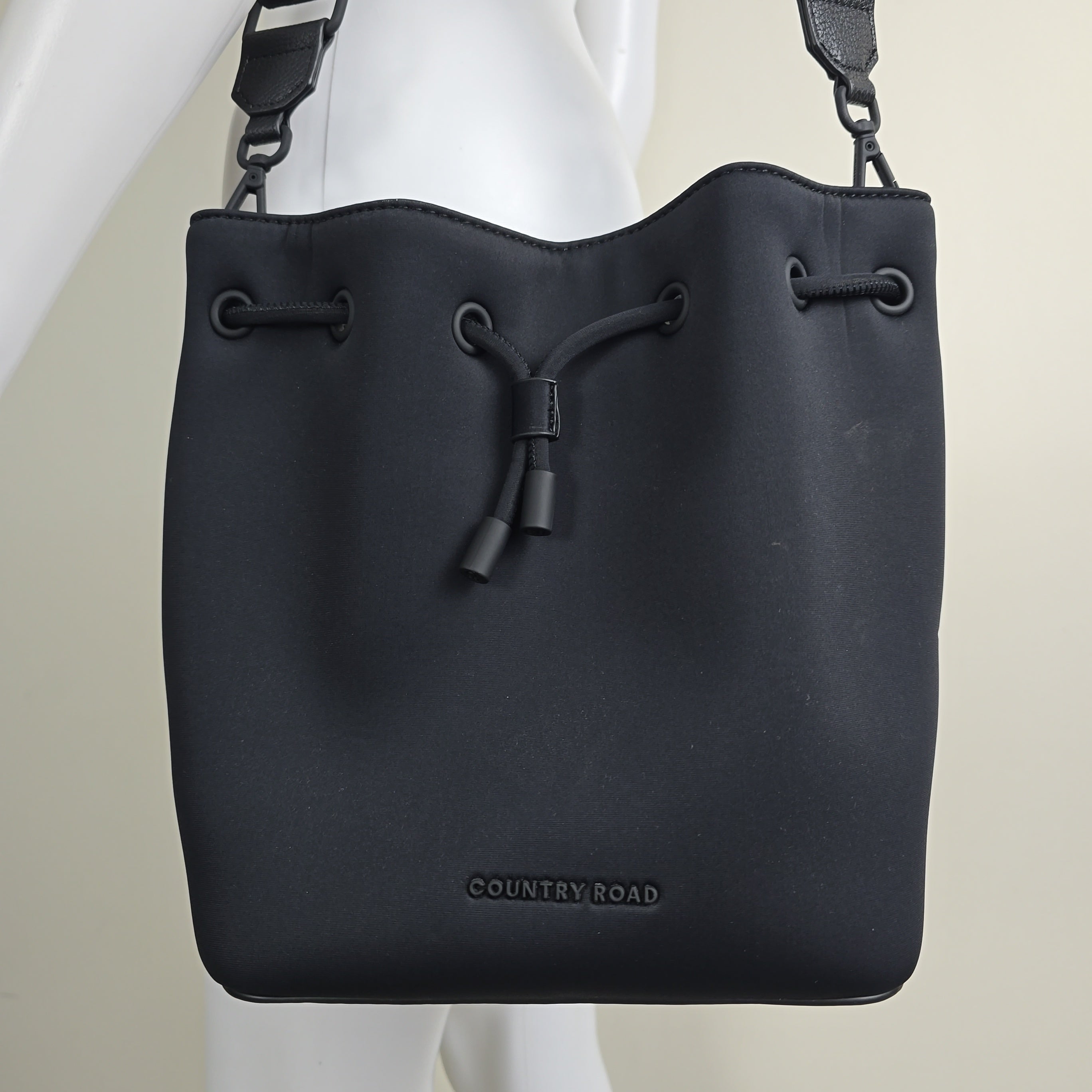 Black drawstring bag with 'COUNTRY ROAD' branding on a light background