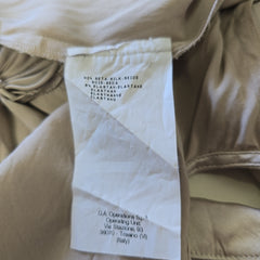 Close-up of beige pants with a label on a beige background