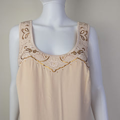Beige lace-trimmed garment on a mannequin with a neutral background