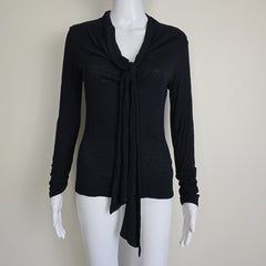 Black top on a mannequin against a plain background