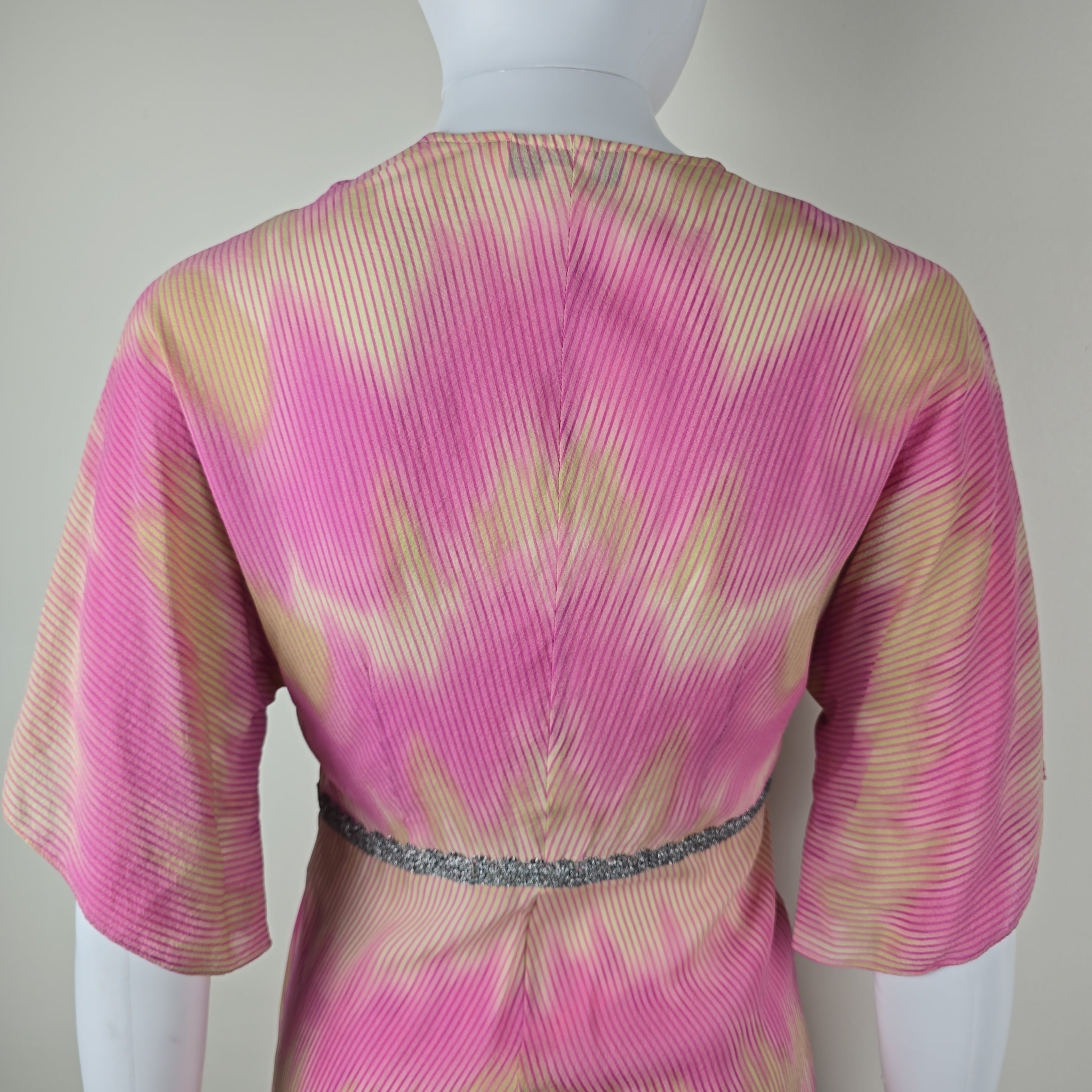 Close-up of a pink and beige patterned top on a white background