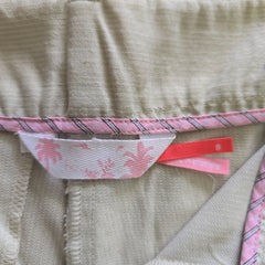 Close-up of a fabric with a pink and white label on a beige background