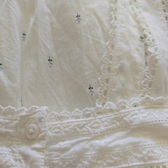 Close-up of a white embroidered fabric with intricate patterns