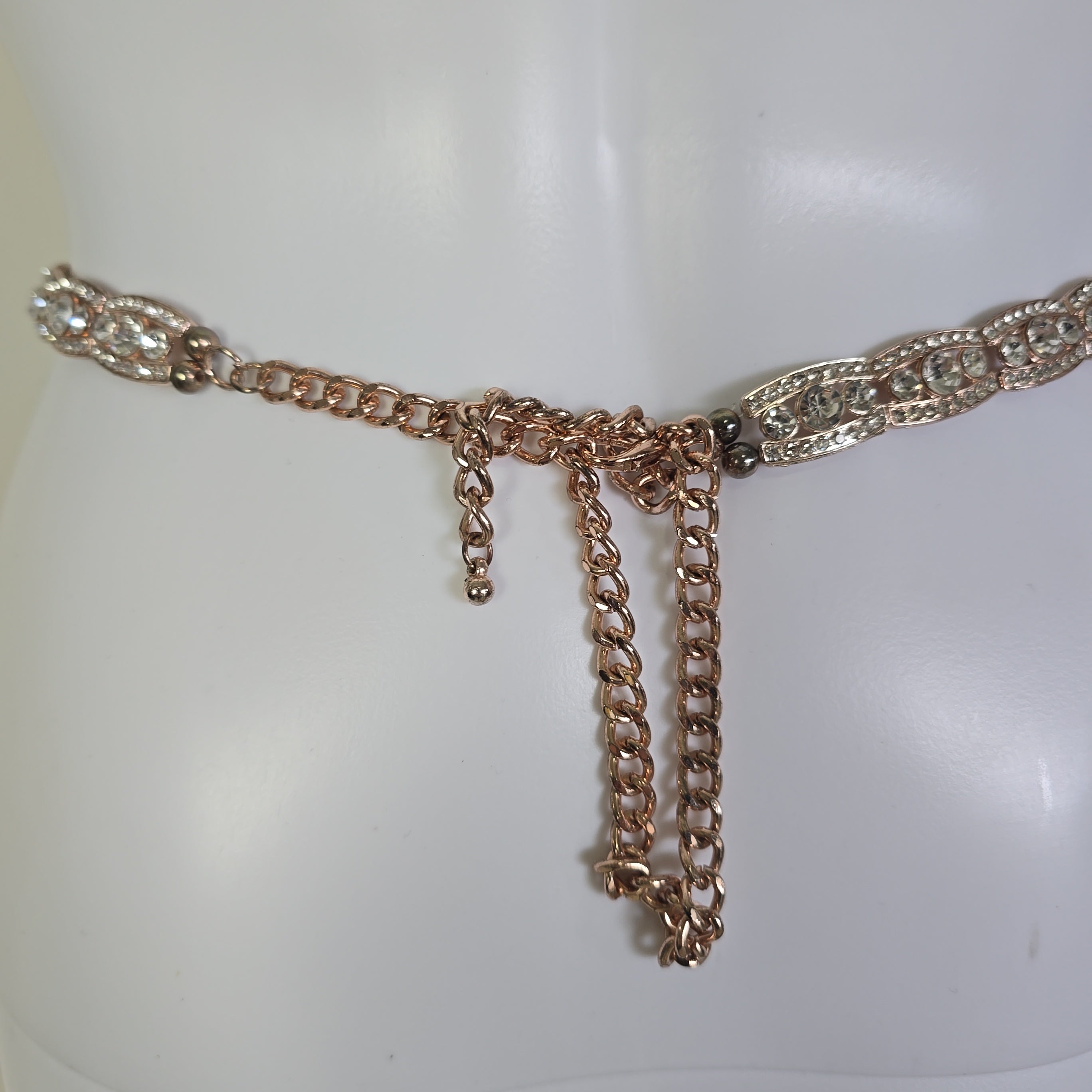 Rose gold belt on a mannequin against a white background