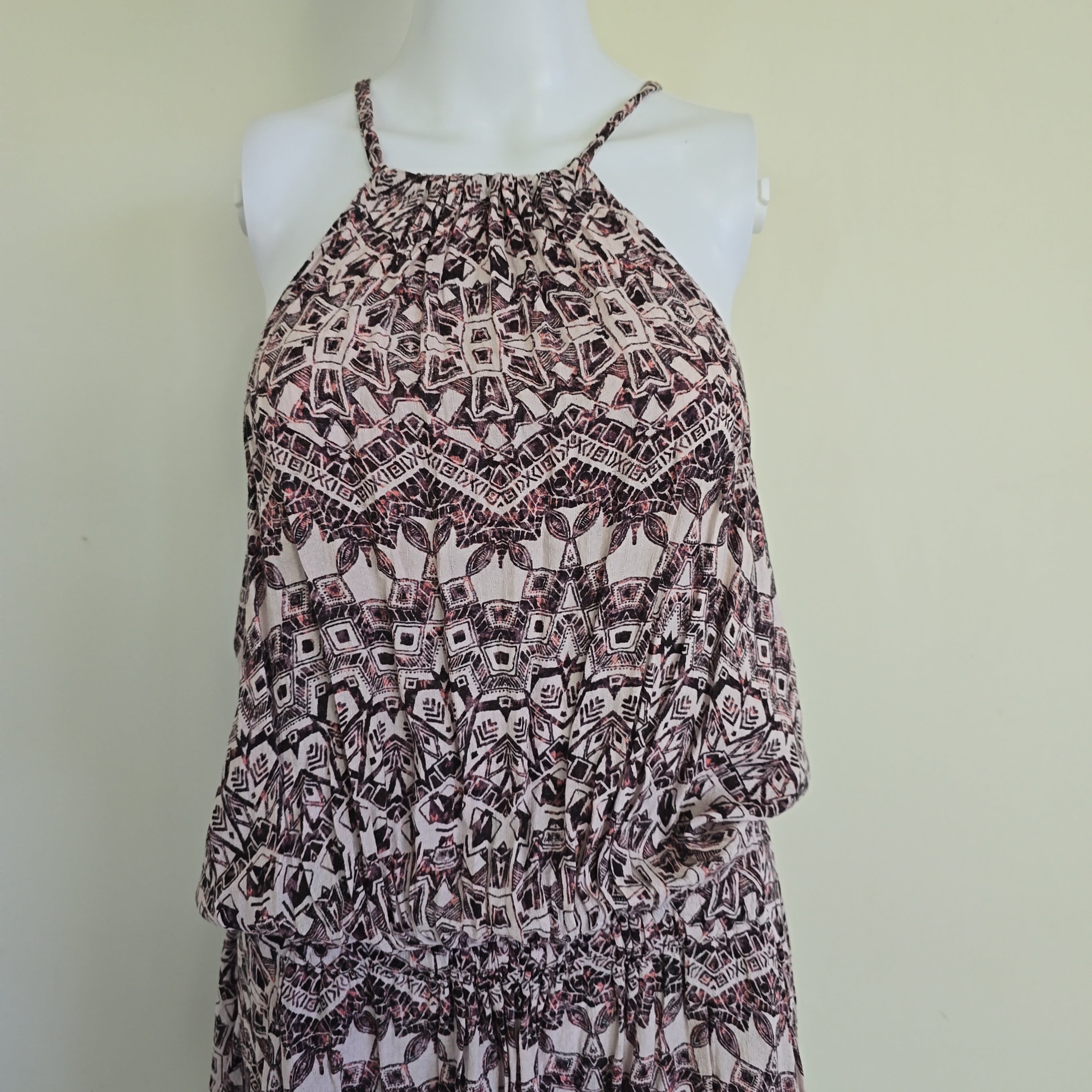 Patterned dress on a mannequin against a plain background