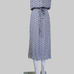 Patterned dress on a neutral wall.