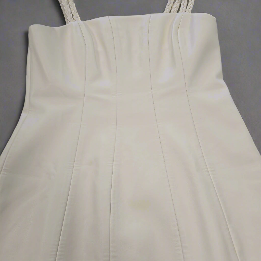 Close-up of a strapless white dress on a tiled floor