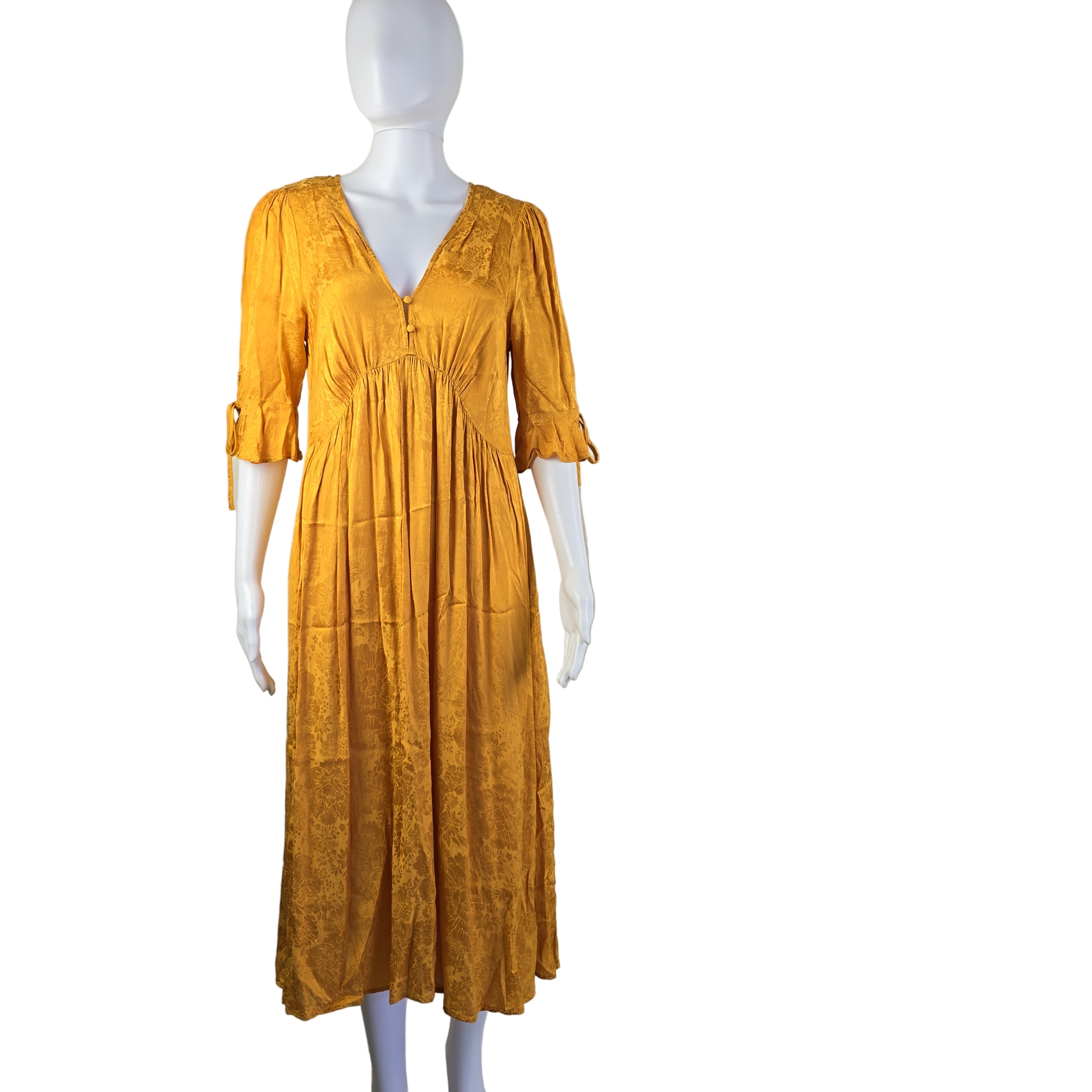 Yellow dress on a mannequin against a plain background