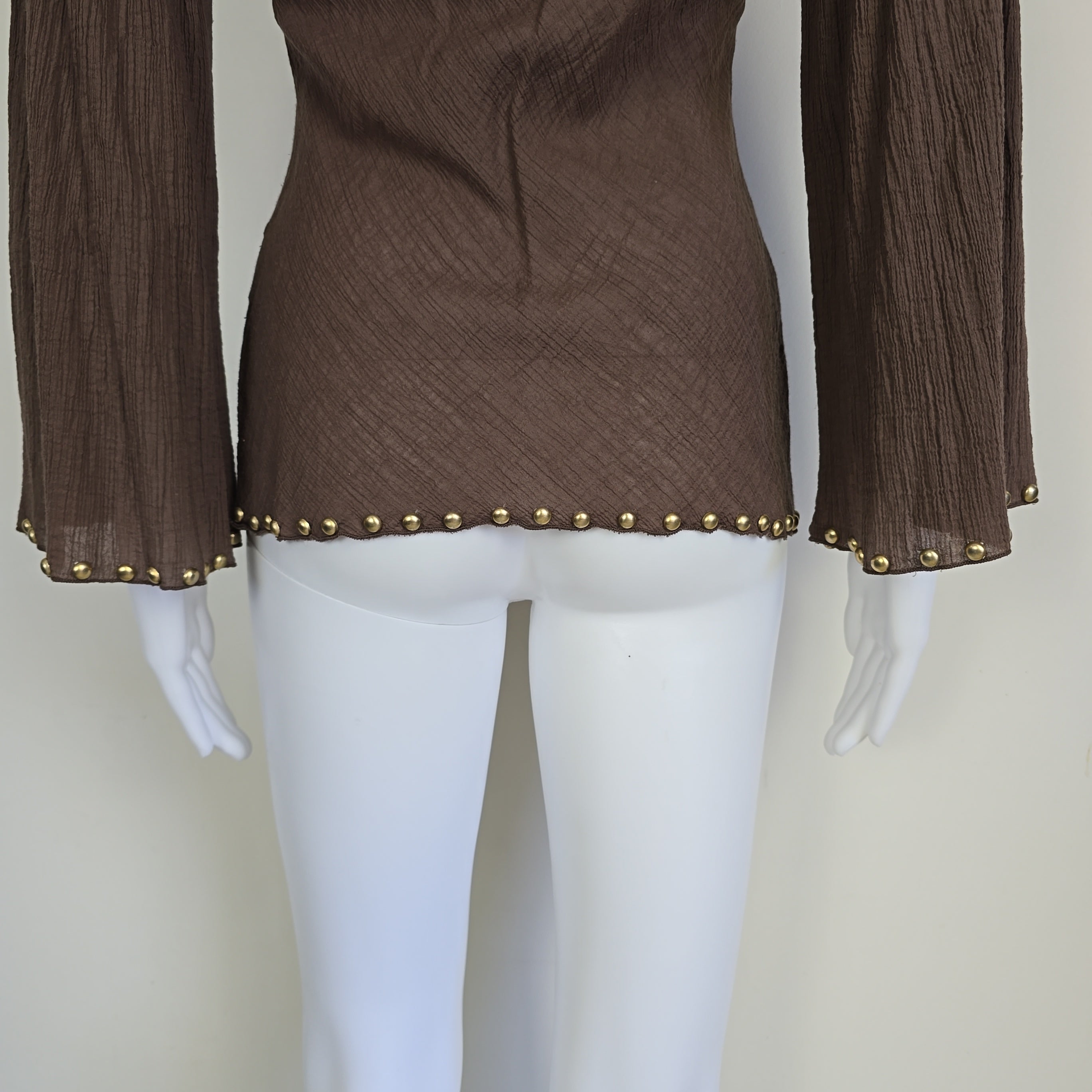 Brown fabric with gold studs on a mannequin against a beige background