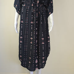 Black dress with floral pattern on a mannequin against a white background
