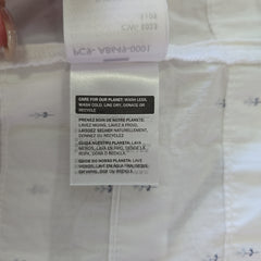 Close-up of a label on a white shirt with text and symbols.