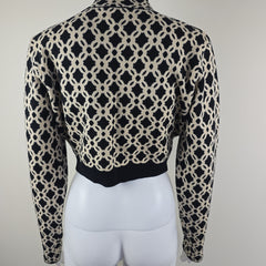Black and white patterned top on a mannequin arm against a white background