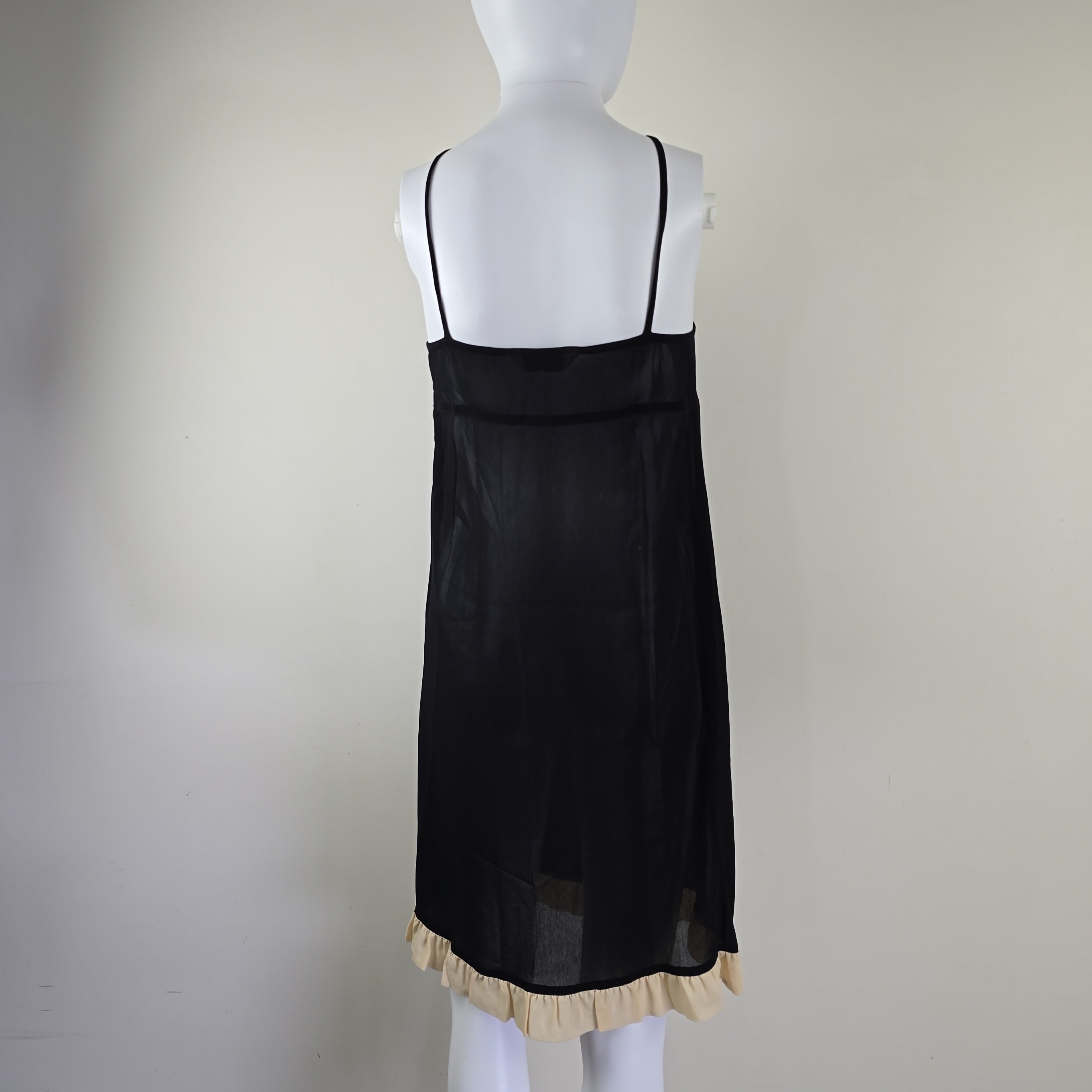 Black sheer skirt with ruffled hem on a mannequin against a plain background