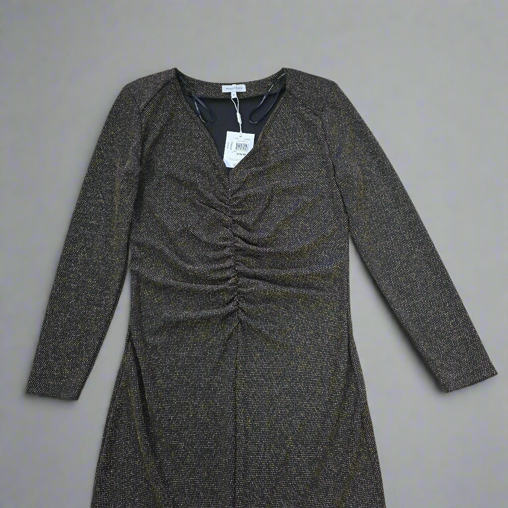 Black and gold textured dress against a light gray background