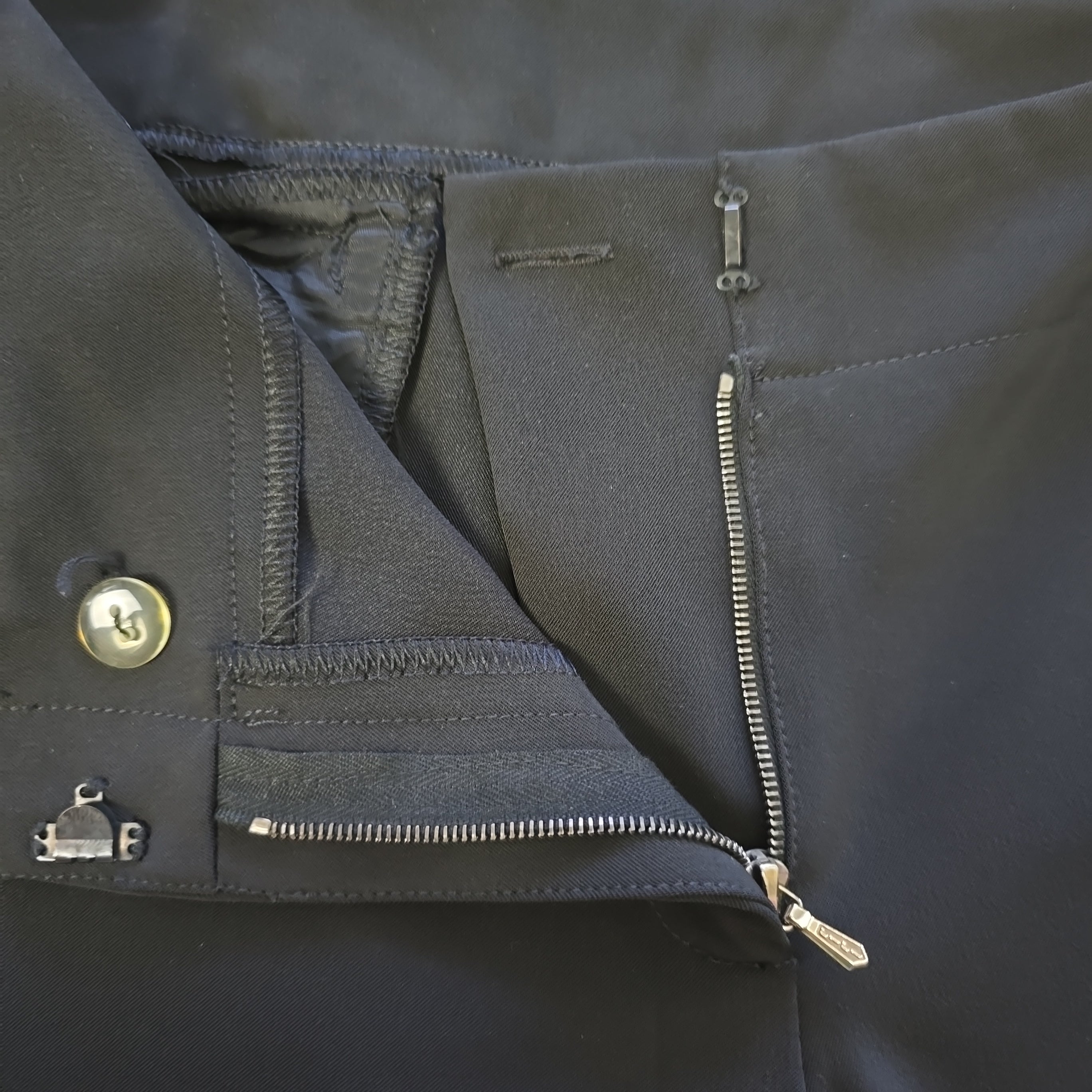 Close-up of a dark pants with zippers and buttons