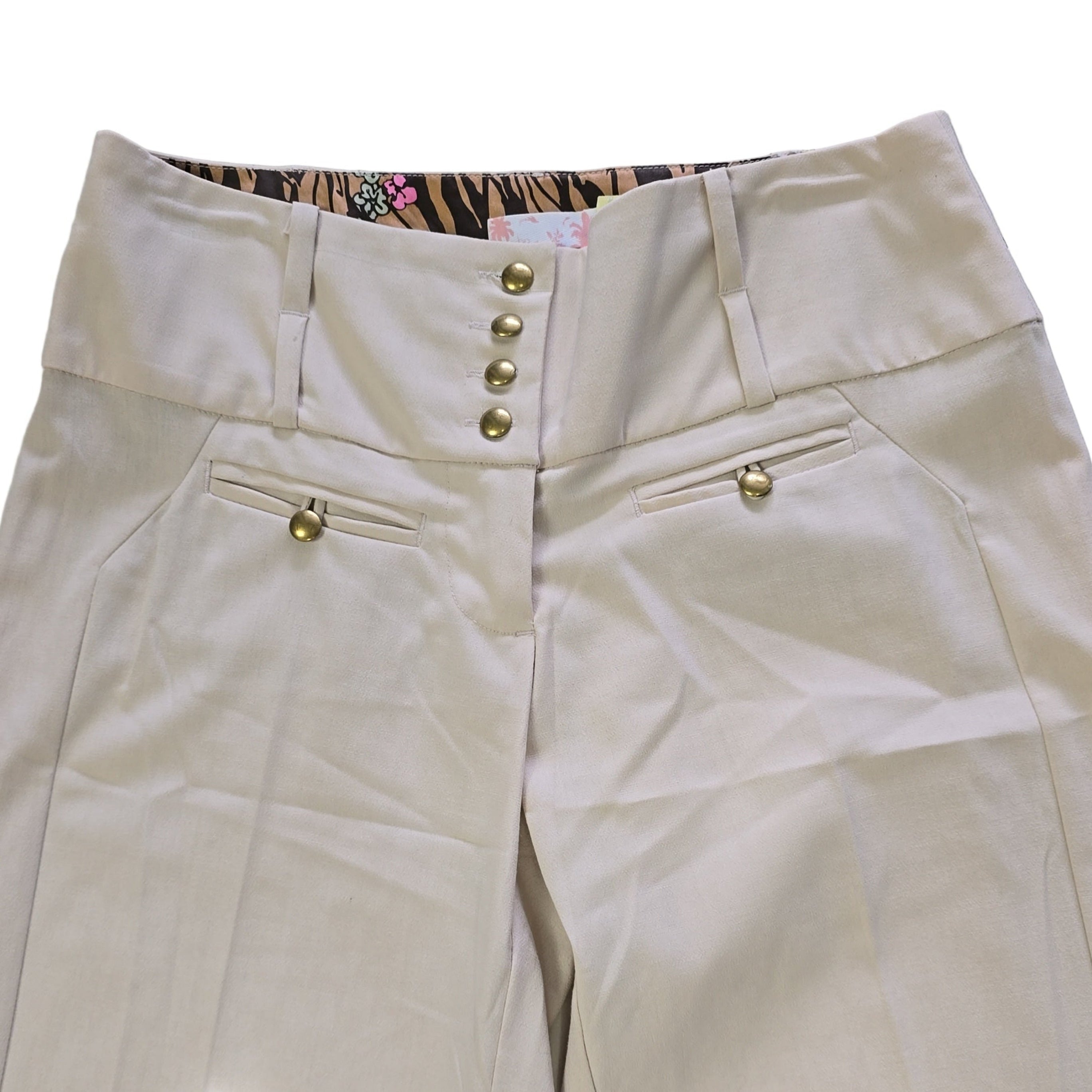 Beige pants with gold buttons on a light backgound