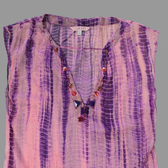 Purple and pink patterned fabric with beads on a tiled floor