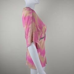 Mannequin wearing a pink and gold patterned garment on a plain background