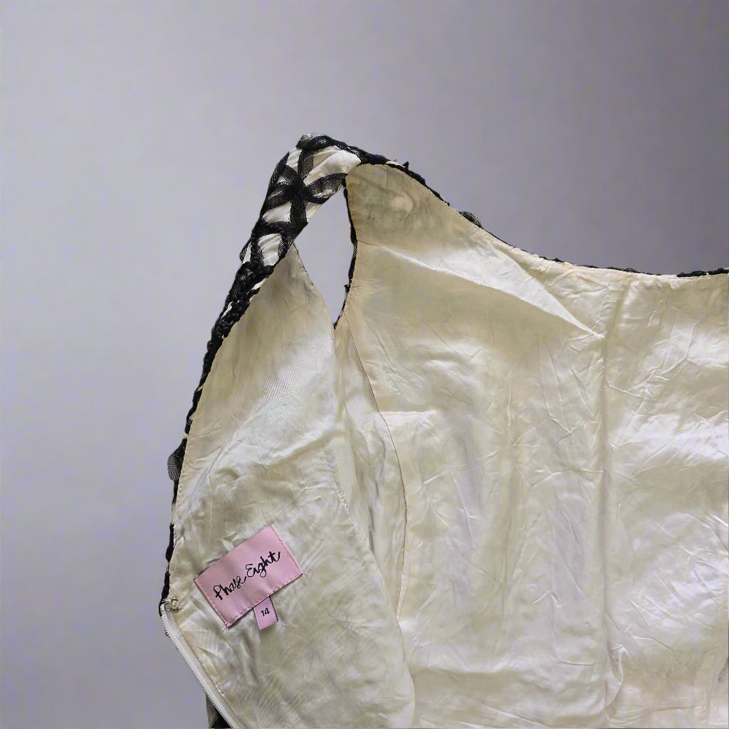 White fabric with black border and pink labels on a tiled floor