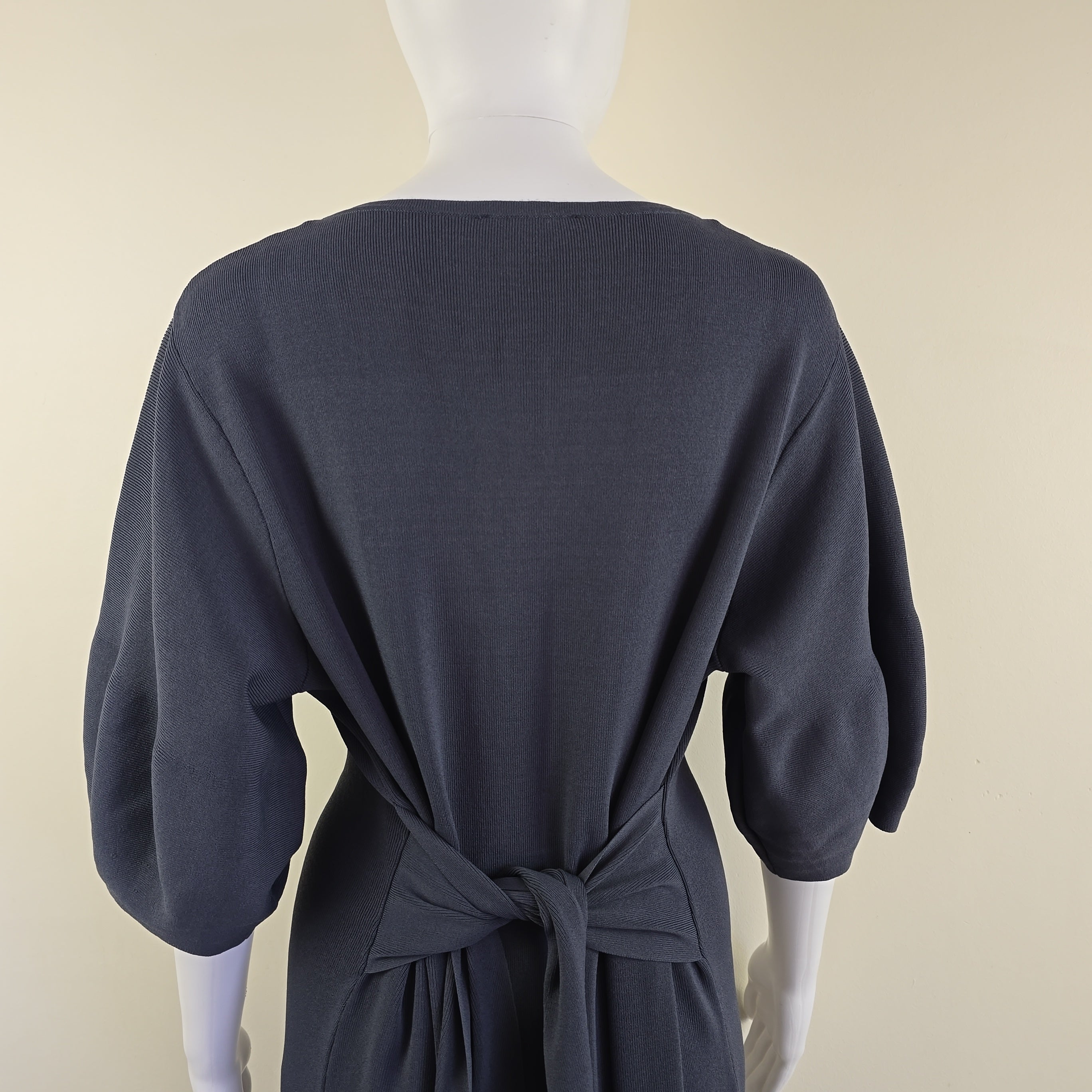 Grey dress on a mannequin against a beige background