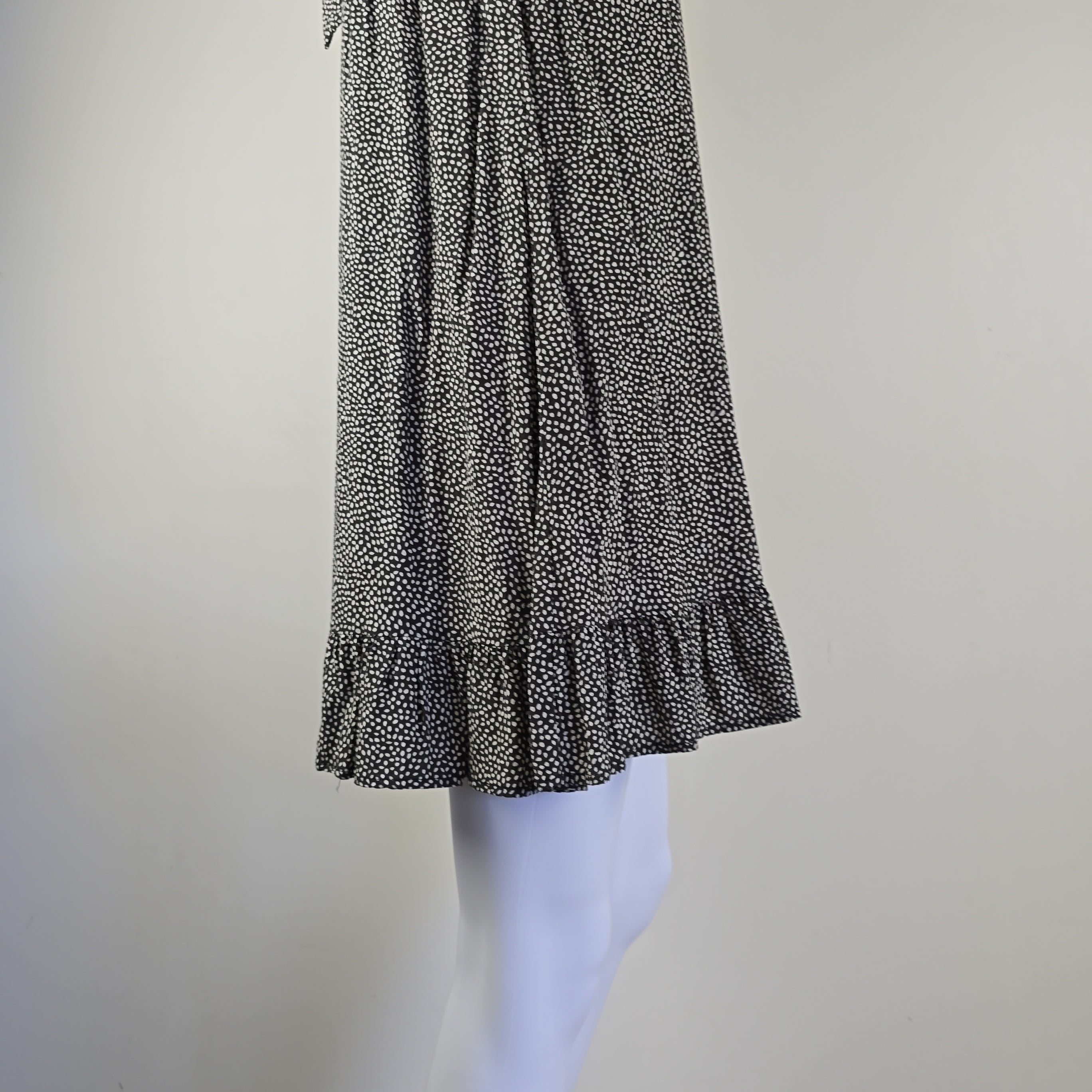 Grey and white spotted patterned dress on a light background