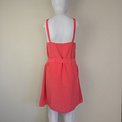 Pink dress on a mannequin against a plain background