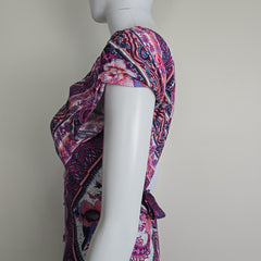 Mannequin wearing a colorful patterned garment on a plain background